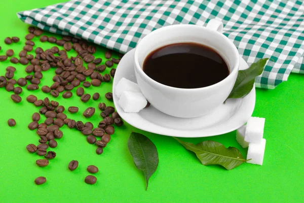 overhead view of Cup of coffee on green background.