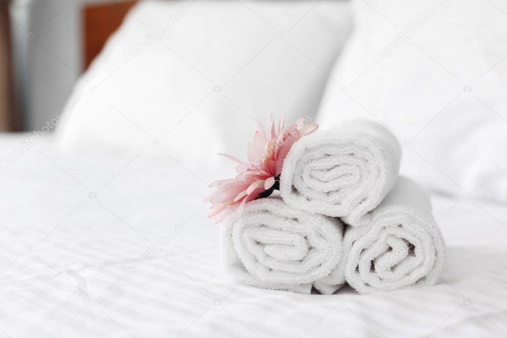 close up of towels and flower on bed in hotel room