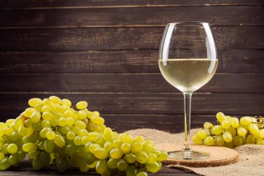 şarap cam ve ahşap masa üzerinde üzüm salkımı