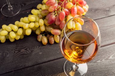 Ahşap masa üzerinde Üzüm dalları ile şarap