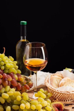Koyu arka plan üzerinde taze üzüm ve şarap
