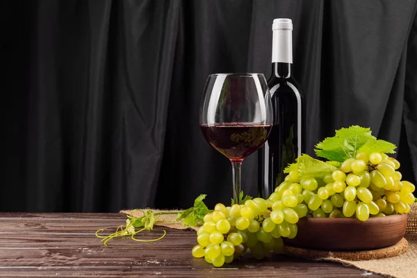 Wine and fresh grapes on dark background