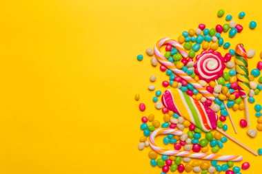 sarı arka plan üzerinde renkli şekerler, yakın çekim