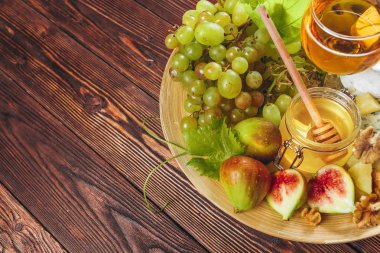 Üzüm, peynir, incir ve bal ile ahşap masa şarap