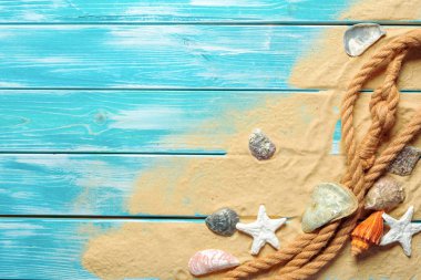 deniz mavi ahşap arka plan üzerinde kum üzerinde deniz kabukları ile deniz ip. Üstten görünüm