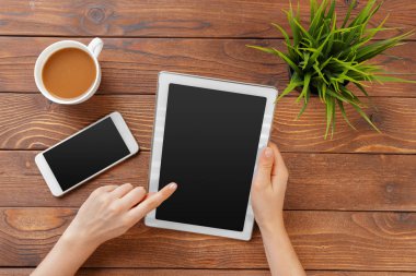 Dijital tablet ve ahşap bir masa üzerinde kahve ile kız el