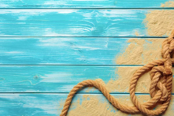 海绳索在海沙子在蓝色木背景 顶视图 — 图库照片