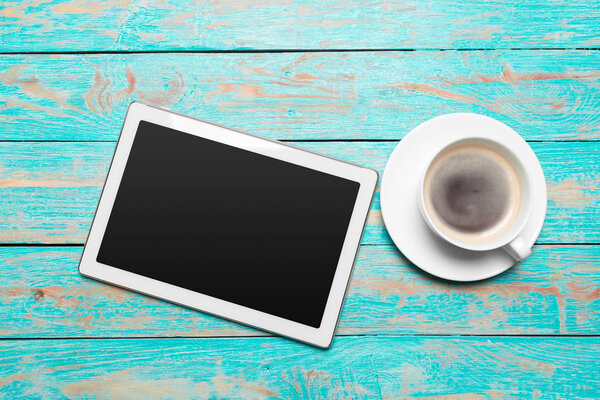 digital tablet and coffee cup on wooden table