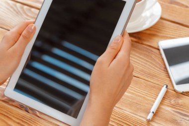 Genç erkek Close-up holding dijital tablet ve içme sabah macchiato eller.