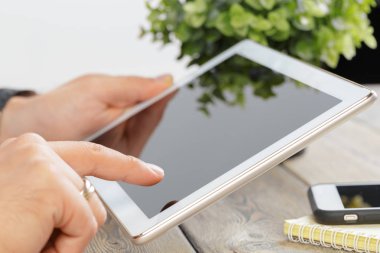 tablet cihaz ahşap çalışma masa üzerinde tutan bir adam elinde