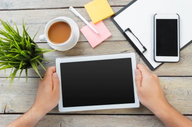 Erkek boş tablet cihaz ahşap çalışma masa üzerinde tutan eller