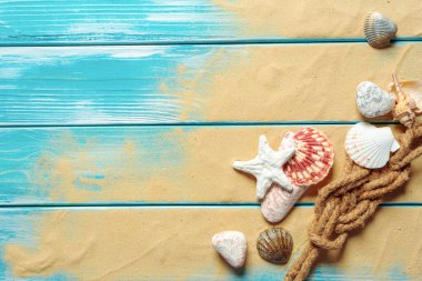 Deniz kabukları ve kum mavi ahşap zemin üzerine