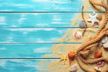 Deniz kabukları ve kum mavi ahşap zemin üzerine