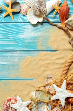 Deniz kabukları ve kum mavi ahşap zemin üzerine