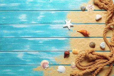 Deniz kabukları ve kum mavi ahşap zemin üzerine