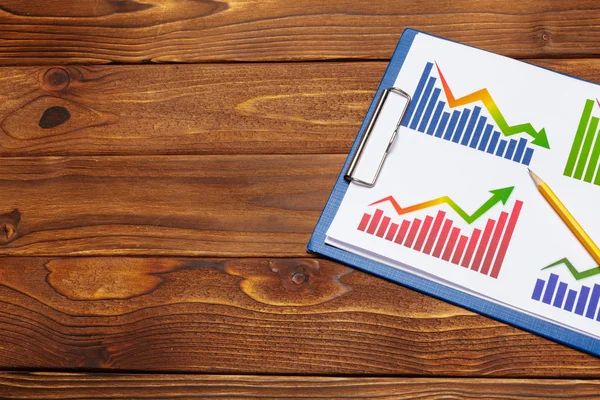 Top view of business paper chart or graph on wooden table