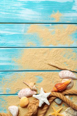 Deniz kabukları ve kum mavi ahşap zemin üzerine