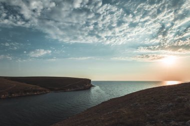 Parlak tatil hedef beach gündoğumu ve deniz kayalıklarla arka plan