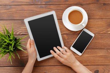 Dijital tablet ve ahşap bir masa üzerinde kahve ile kız el