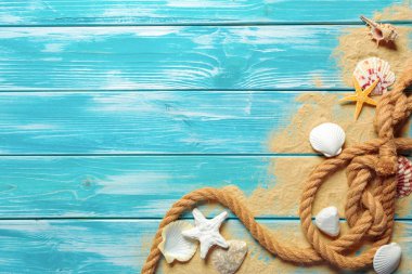 Deniz kabukları ve kum mavi ahşap zemin üzerine