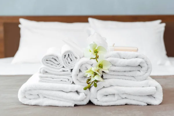 towels and flower on bed in hotel room