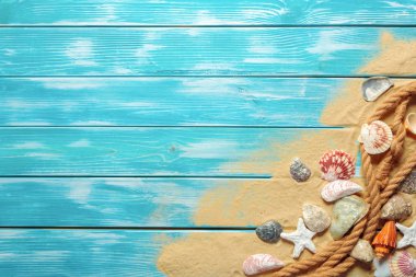 Deniz kabukları ve kum mavi ahşap zemin üzerine
