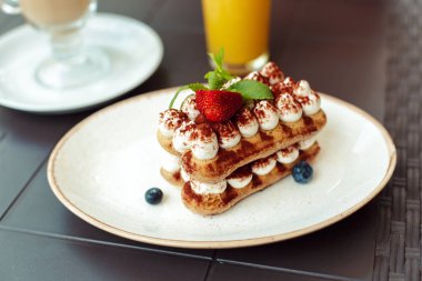 Tiramisu tatlı ve kahve taş masada.