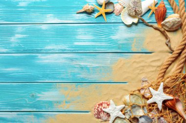 Deniz kabukları ve kum mavi ahşap zemin üzerine