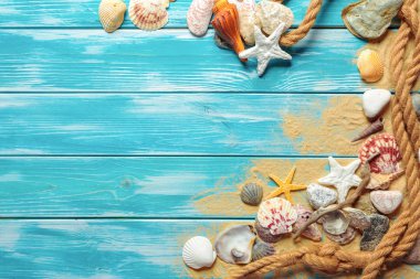 Deniz kabukları ve kum mavi ahşap zemin üzerine