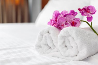 havlu ve yatak otel odasında çiçek