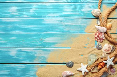 Deniz kabukları ve kum mavi ahşap zemin üzerine