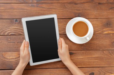 Dijital tablet ve ahşap bir masa üzerinde kahve ile kız el