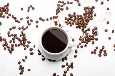 Beyaz arka planda kahve fincanı ve fasulye.