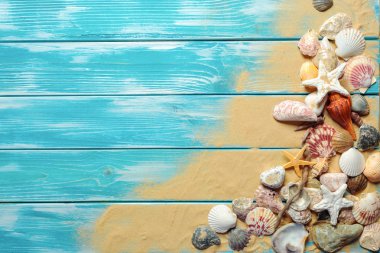 Deniz kabukları ve kum mavi ahşap zemin üzerine