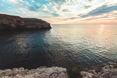 Parlak tatil hedef beach gündoğumu ve deniz kayalıklarla arka plan