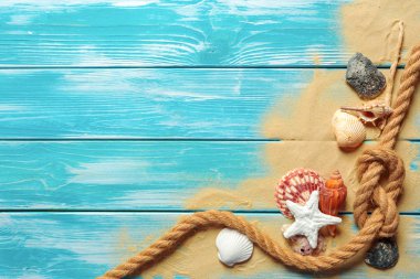 Deniz kabukları ve kum mavi ahşap zemin üzerine