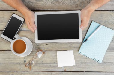 Erkek boş tablet cihaz ahşap çalışma masa üzerinde tutan eller