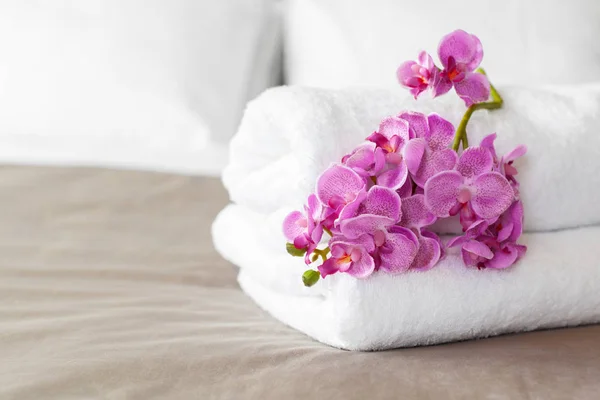 towels and flower on bed in hotel room