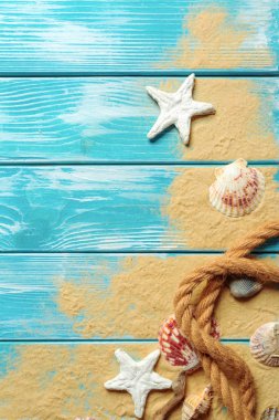 Deniz kabukları ve kum mavi ahşap zemin üzerine