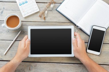 Erkek boş tablet cihaz ahşap çalışma masa üzerinde tutan eller