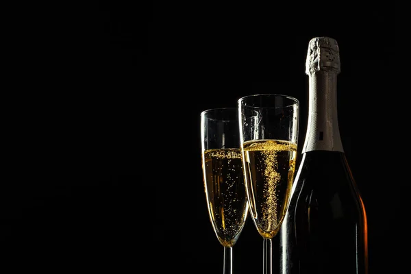 シャンパンと暗い背景の上のガラスの瓶 — ストック写真