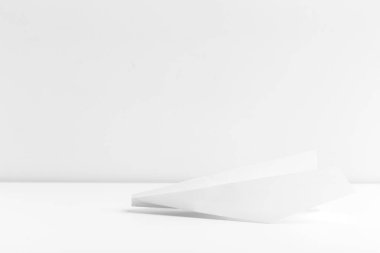 Düz beyaz kağıt uçak beyaz renk arka plan üzerinde yatıyordu