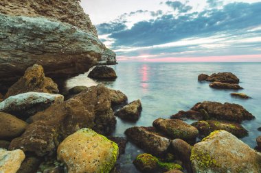 Parlak tatil hedef beach gündoğumu ve deniz kayalıklarla arka plan