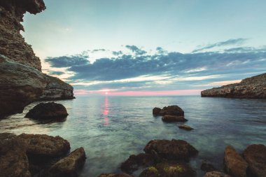 Parlak tatil hedef beach gündoğumu ve deniz kayalıklarla arka plan