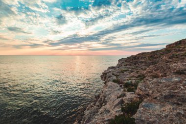 Parlak tatil hedef beach gündoğumu ve deniz kayalıklarla arka plan