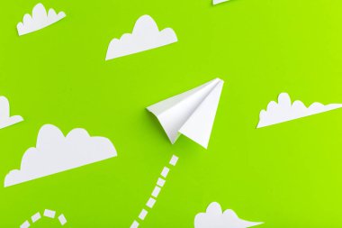 Kağıt uçak yeşil arka plan üzerinde noktalı çizgiler ile bağlı. İş kavramı