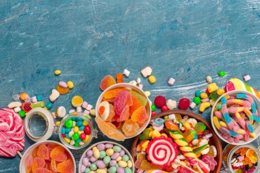 Mavi arka plan üzerinde renkli şekerler karışık 