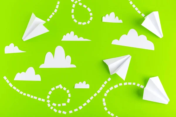 Paper airplanes  connected with dotted lines on green background. Business concept