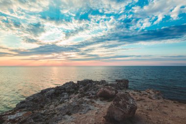 Parlak tatil hedef beach gündoğumu ve deniz kayalıklarla arka plan