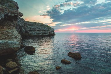 Parlak tatil hedef beach gündoğumu ve deniz kayalıklarla arka plan